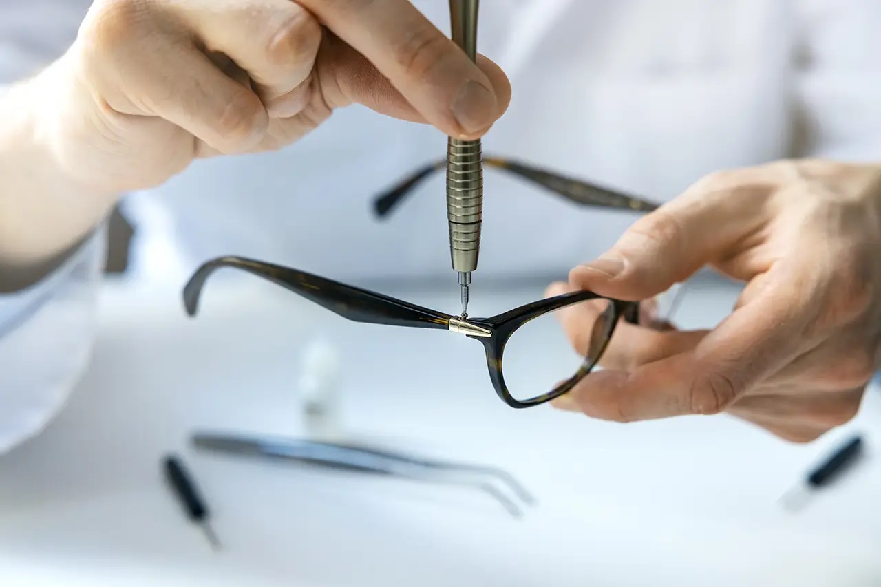 optical-technician-repairing-eyeglass-frame-with-screwdriver